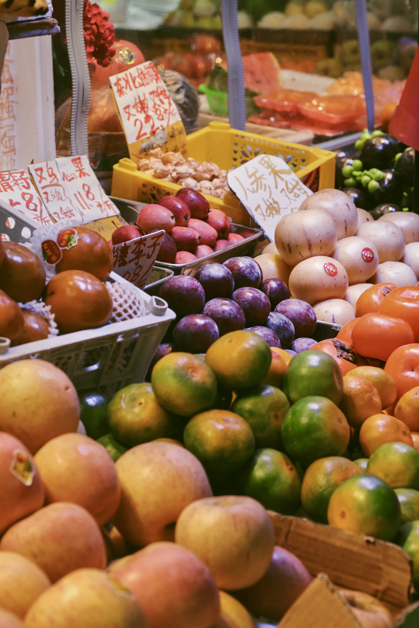 Fresh fruit on display at a market stall with handwritten Chinese price signs