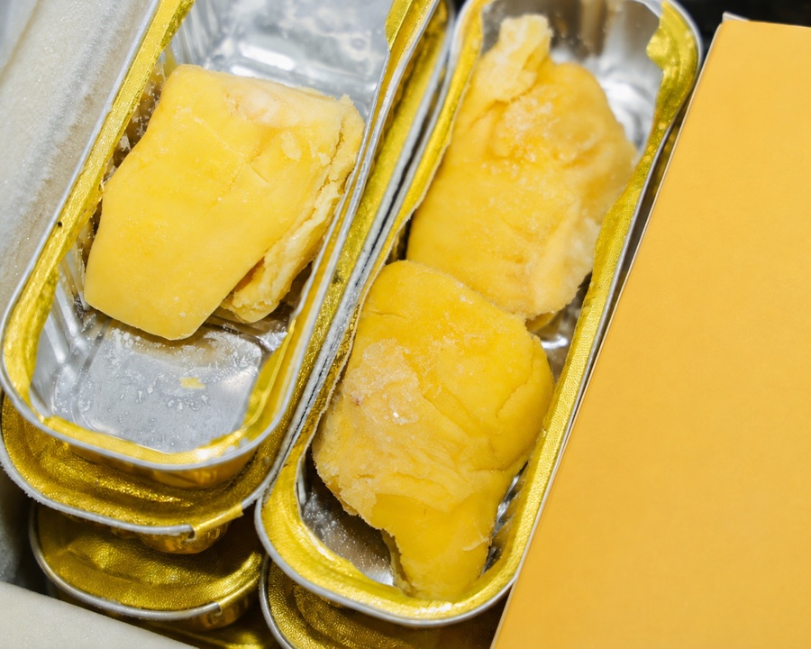 Frozen durian flesh presented in gold product trays